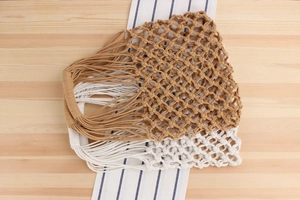Close-up of handmade hollow cotton rope woven bags in khaki and white mesh colors