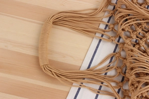 Detail of hand-woven cotton rope handle and mesh pattern on a khaki beach tote bag