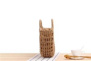 Detail of woven straw handbag featuring hollow mesh texture and drawstring lining