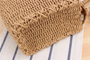 Detailed close-up of handmade straw bag woven texture with metal ring and reinforced stitching