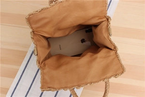 Top view of woven straw handbag interior showing brown fabric lining and storage capacity