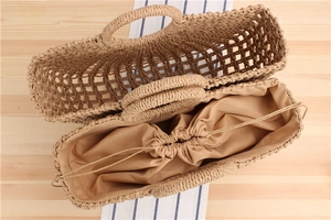 Detail of hand-woven paper rope beach bag with hollow mesh pattern and drawstring liner