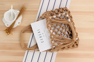 Detailed top view of handmade hollow woven cotton rope beach bag on a wooden table
