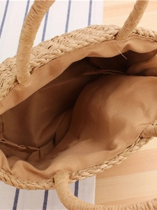 Interior view of handmade woven straw beach bag with soft brown lining and top handle