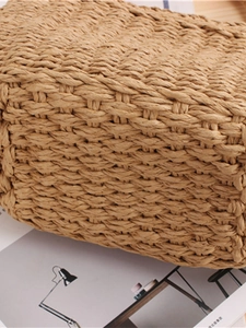 Handmade woven straw beach bag in natural tan with tight cross-weave texture details