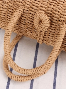 Handcrafted straw woven crossbody bag with round handle and button closure in natural khaki