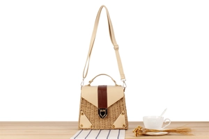 Detail of paper straw woven bag with cream leather flap and vintage metal lock closure