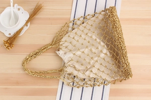 Detail of woven metallic gold mesh beach bag with a beige drawstring fabric inner lining