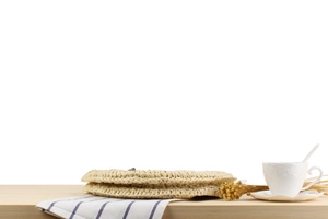 Gros plan d'un sac rond en corde de papier tressé beige sur une table en bois clair