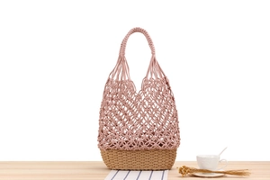Detail showing the pink cotton rope weave and beige woven base of this bohemian tote bag