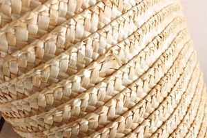 Macro shot of natural straw bag showing intricate spiral woven texture and fiber detail