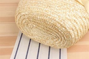 Close-up of reinforced spiral weave technique on the base of this straw shoulder bag