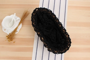 Detail of handmade hollow woven shoulder bag with black cotton rope and natural grass straw