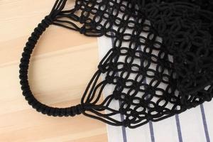 Close-up of black handmade woven mesh bag showing intricate cotton rope knots and handle