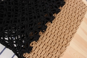 Detail of hand-woven mesh pattern with black cord and natural straw texture contrast
