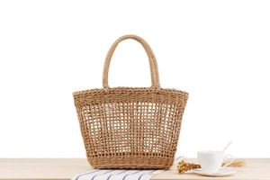 Detailed macro view of hollow-out woven texture on a beige handmade straw tote bag