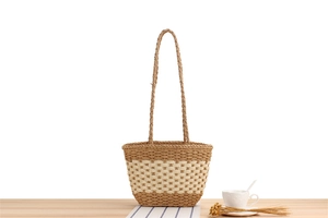 Detail of hand-woven paper rope shoulder bag featuring bicolor brown and beige texture