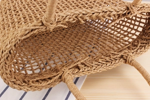 Close-up of hollow woven straw handbag showing natural texture and detailed mesh patterns