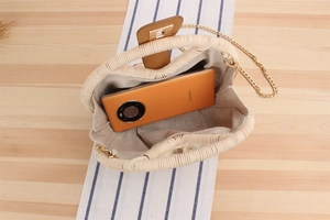 Vista interna della borsa in paglia intrecciata beige con spazio per uno smartphone