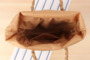 Detailed interior of woven straw bag with fabric lining and convenient inner pocket