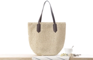 Détail du sac cabas en paille de papier avec poignées en cuir marron et coutures renforcées