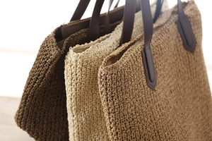Détails de sacs en paille tissée beige et marron avec des anses en cuir robustes