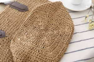 Détail de la base en corde de papier tissée et du renfort en cuir d'un sac de plage
