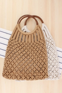 Detailed macro view of handmade macrame tote bag with dark brown circular wood handles