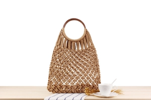 Detail of bohemian hand-woven cotton net bag featuring a round solid wood ring handle