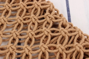 Macro shot of handcrafted brown cotton rope mesh detailing on a woven summer beach bag
