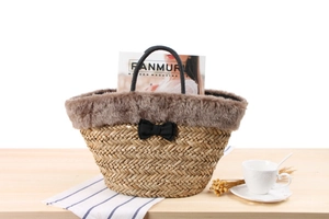 Detailed shot of straw tote bag with brown faux fur trim and elegant black fabric bow