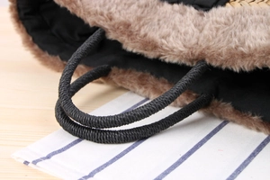 Detail of hand-woven beach bag featuring faux fur trim and durable black rope handles