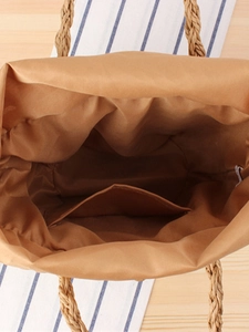 Top view of woven paper rope tote bag interior with fabric lining and straw handle