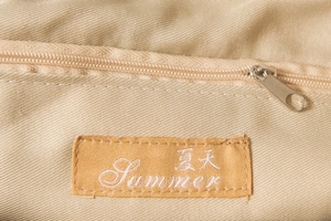 Vue détaillée de la doublure beige du sac tissé avec zip et étiquette Summer