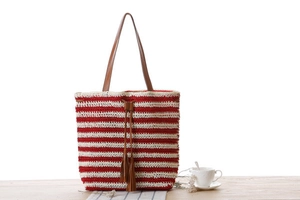 Detail of red and white striped crochet beach bag with leather drawstring and tassels