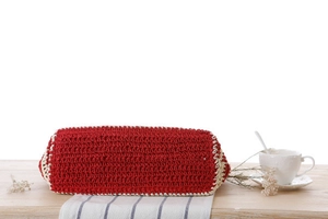 Detailed macro view of the oval red and beige striped woven base of the crochet beach bag