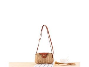 Détail du sac bandoulière en paille tressée avec sangle en cuir brun et fermoir doré