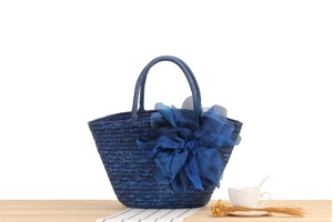 Detail of navy blue straw tote with 3D silk flowers and circular woven handles