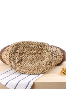Handmade woven straw beach bag for women featuring a detailed oval bottom and rustic texture
