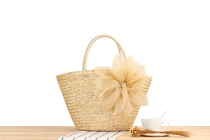 Detailed close-up of straw woven tote bag featuring a large decorative silk flower