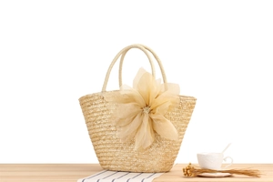 Detailed texture of straw woven tote bag featuring large 3D floral mesh decoration
