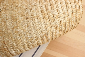 Detailed close-up of natural woven texture on a beige straw bag for beach vacation