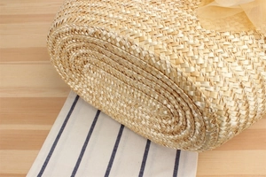Detailed close-up of handmade woven straw bag with soft yellow silk ribbon decoration