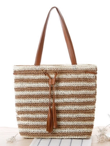 Handwoven striped straw tote bag with brown leather straps and decorative tassels