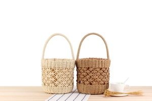 Detail of hand-woven straw bucket bags with hollow diamond patterns and fabric lining