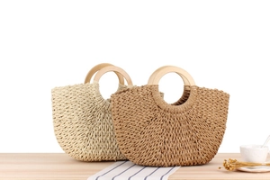 Detail of paper rope woven bags with wooden handles in light beige and dark brown colors