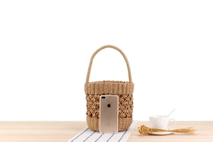 Detail of hand-woven bucket bag with inner lining and iPhone for size reference