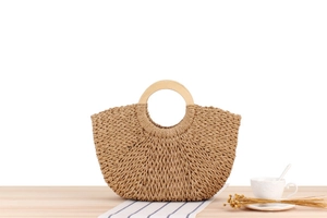 Detailed close-up of handmade woven paper rope bag with circular wooden handles and texture