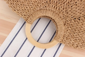 Detailed view of handmade woven paper rope bag with circular wooden handle texture