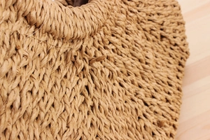 Detailed close-up showing the intricate woven paper rope texture of the beach handbag
